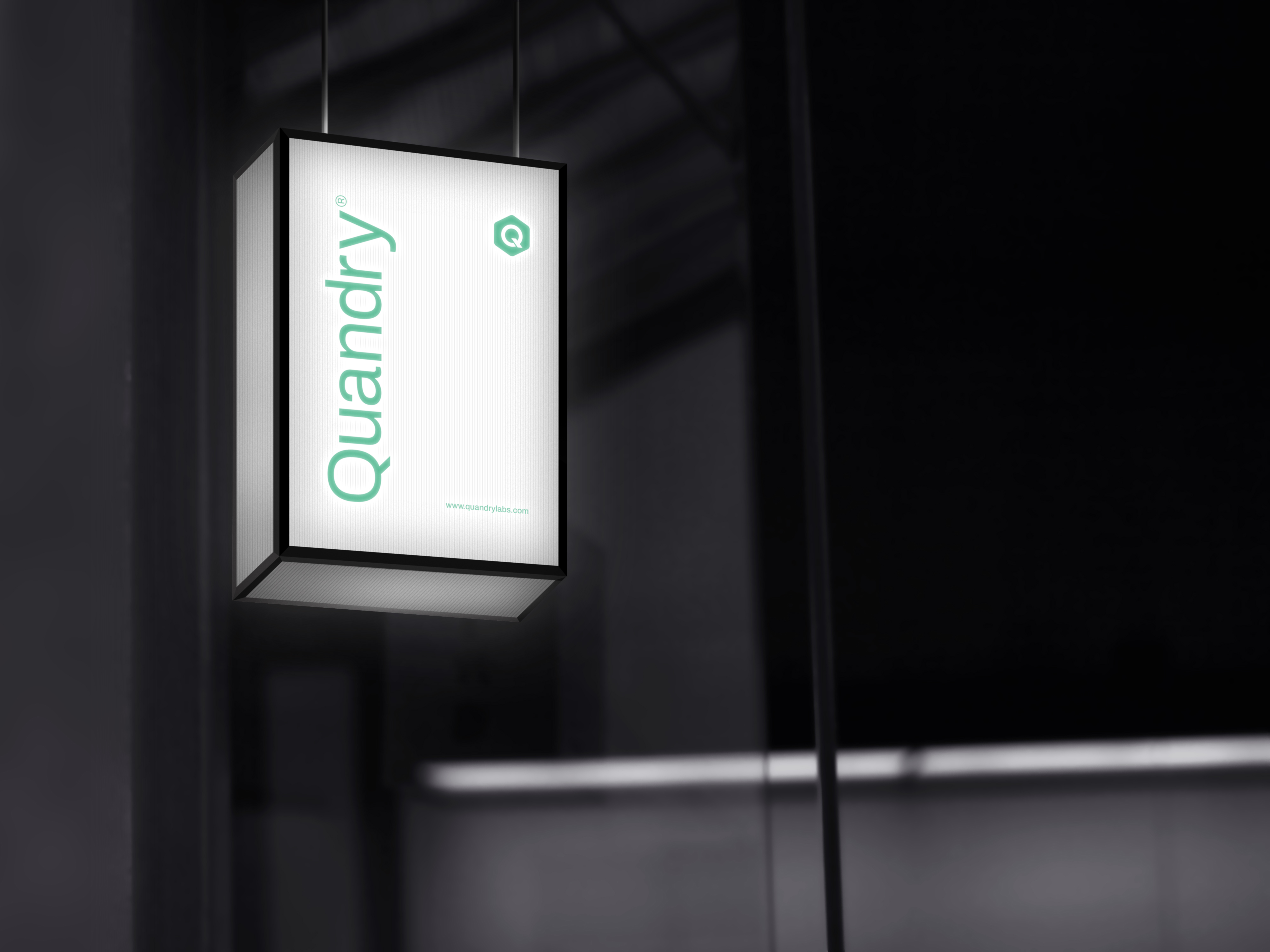 Quandry lightbox sign hanging in a dark architectural space